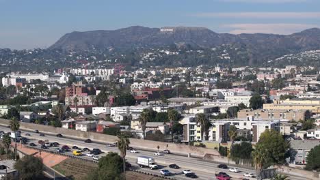 East-Hollywood-Sobre-El-Tráfico-De-La-Autopista-101,-El-Barrio-Y-El-Famoso-Cartel-Durante-El-Día,-Vista-Aérea