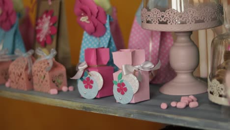 Female-hands-placing-handcraft-paper-box-on-shelf-in-line-of-other-presents