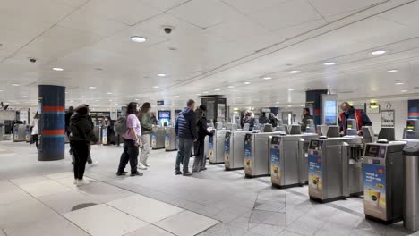 People-are-passing-through-the-contactless-ticket-barriers-at-Oxford-Street-station-in-London,-England,-the-concept-of-urban-mobility-and-transit-efficiency