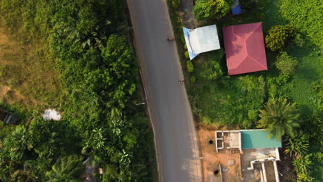 Top-down-drone-shot-over-a-street-in-Ebolowa-city,-golden-hour-in-south-Cameroon