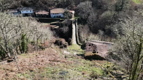 Roman-bridge-crosses-river,-view-down-historic-brick-work,-aerial-pan