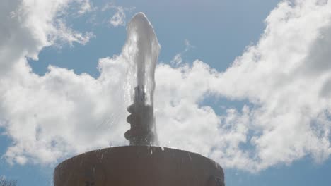 Steinbrunnen-Mit-Einem-Wasserstrahl-An-Einem-Bewölkten-Tag