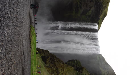 Vídeo-Vertical-De-4.000-Turistas-Bajo-La-Cascada-De-Skogafoss-En-El-Húmedo-Día-De-Primavera-De-Islandia