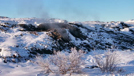Geothermal-field-in-Iceland,-near-Myvatn-Lake,-releasing-gases-from-volcanic-activity,-pan