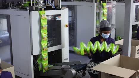 pov-shot-Men-are-arranging-packets-of-chips-inside-the-box-taking-them-out-of-the-machine