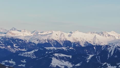 Luftaufnahme-Einer-Drohne,-Die-Die-Silhouette-Schneebedeckter-Berge-Bei-Sonnenaufgang-Einfängt