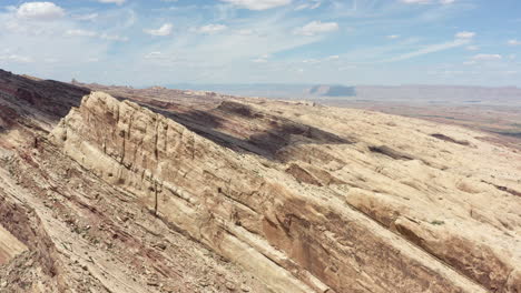 Atemberaubender-Panorama-Drohnenclip-über-Dem-Felsigen-Gelände-Mit-Einer-Schlucht-Im-Hintergrund-Der-Roten-Sandsteinklippen-Im-San-Rafael-Reef-In-Utah,-USA