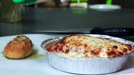 Fresh-baked-cheesy-lasagna-with-a-seasoned-and-oiled-garlic-bread-roll