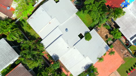 Aerial-drone-of-Block-of-Units-Top-Down-Ascends-Above-Corrugated-Roof-and-Tan-Driveway