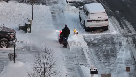 Man-snow-blowing-sidewalk-after-heavy-snow-storm-in-northeast-USA