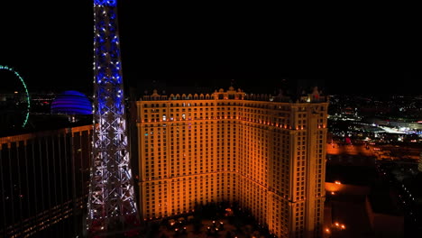 Aerial-rising-shot-in-front-of-the-illuminated-Paris-Las-Vegas-hotel,-night-in-USA
