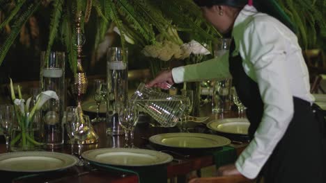 Professional-waitress-woman-serving-water-in-crystal-glasses-during-wedding-reception