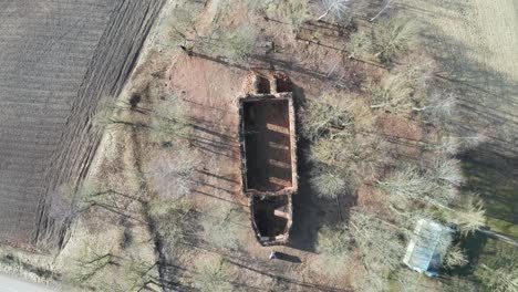 Aerial-top-down-descend-over-abandoned-church-wall-outline-remains