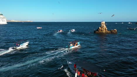 Aerial-view-following-a-boat,-driving-on-the-coast-of-sunny-Cabo-San-Lucas,-Mexico