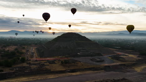 Hot-air-balloons-flying-around-the-Temple-of-the-sun,-cloudy-morning---Aerial-view