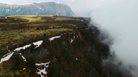 Einschaltaufnahme,-Die-Einen-Mit-Nebel,-Wolken-Und-Grüner-Vegetation-Bedeckten-Klippenrand-Zeigt---Seiser-Alm-Berggipfel