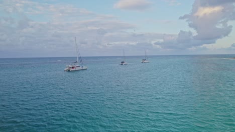 Vor-Touristen-Verankerte-Katamarane-Zeigen-Den-Sonnenuntergang-Im-Kristallklaren-Wasser-Der-Dominikanischen-Republik