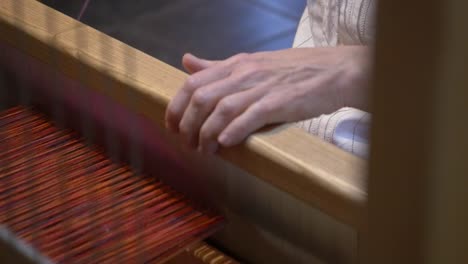 WOMAN-WORKS-ON-A-TRADITIONAL-LOOM-MAKING-A-SCARF