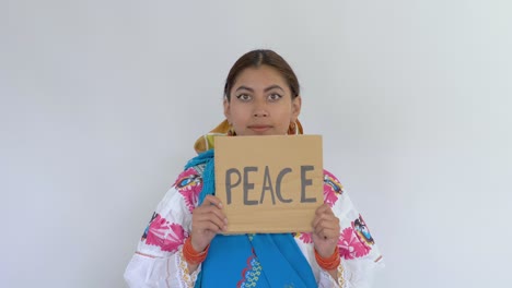 Film-clip-of-a-young-brunette-Latina-dressed-in-traditional-Cayambe-costume-displaying-a-message-saying-"Peace"