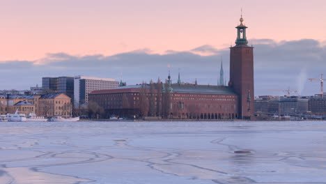 Iconic-red-brick-Stockholm-City-Hall-overlooking-frozen-Lake-Mälaren