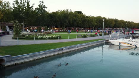 Amazing-flowery-and-green-park-with-walking-tourists-during-high-season-in-Balatonfured,-Hungary