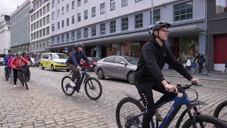 People-Riding-Bicycles-in-Downtown-Bergen,-Norway,-Slow-Motion