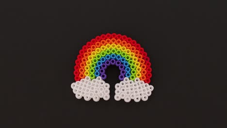 Colorful-bead-rainbow-on-black-background,-simple-and-creative-kids-craft-project