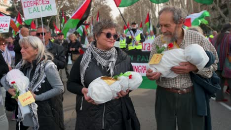 Demonstranten-Halten-Stoffbündel-Mit-Der-Abbildung-Eines-Toten-Babys-Während-Eines-Solidaritätsmarsches-Für-Palästina