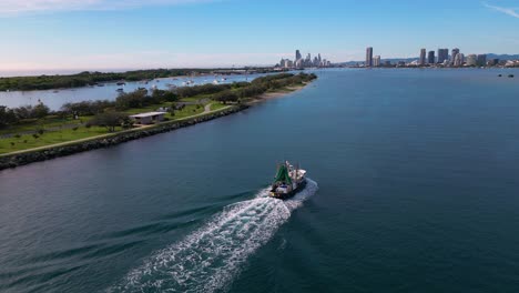 Left-to-right-aerial-views-following-a-trawler-over-the-Broadwater-as-it-returns-to-the-Gold-Coast,-Australia