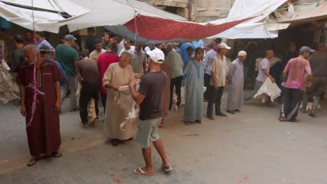 Thorough-leather-selection-and-negotiation-between-vendor-and-buyer-at-the-local-marketplace-in-Fez,-Morocco