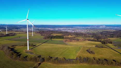 Anmutige-Windräder-über-Grünen-Feldern-Vor-Einem-Lebendigen-Himmel