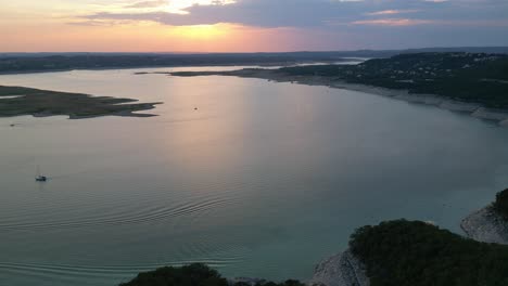 Small-ripples-disturb-the-flat-water-during-a-colourful-sunset-Lake-Travis,-Texas