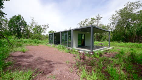 Camino-De-Grava-De-Tierra-Tropical-No-Desarrollado-Hacia-Una-Casa-Estilo-Caja-De-Contenedor-Rectangular-Desmontable-En-La-Selva-Tropical