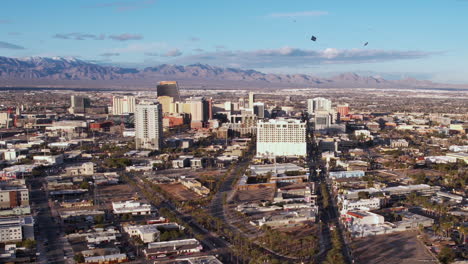 Aerial-View-of-Helicopter-Towing-Banner-Above-Downtown-Las-Vegas-Buildings,-Nevada-USA,-Drone-Shot