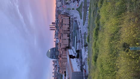 Vertical-footage-left-to-right-pan-shot-of-Madrid-skyline-view-from-Las-Tablas-Viewpoing-during-colorful-beautiful-sunset-with-orange-clouds-and-glow