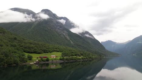 Lakeside-Touristic-Hut,-DNT-Hoemsbu-On-Eikesdalsvatnet-Lake-Shore-in-Norway-Surrounded-by-Mountains,-Aerial-View