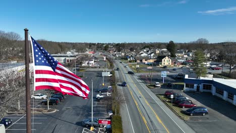 Bandera-Americana-Ondeando-En-La-Carretera-Principal-De-La-Ciudad-Americana-En-Un-Día-Soleado