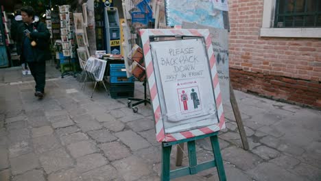 Schild-Mit-Rucksackrichtlinien-Vor-Der-Buchhandlung-In-Venedig,-Buchhandlung-Acqua-Alta