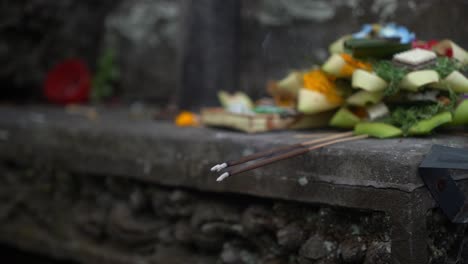 An-image-showing-traditional-offerings-including-food,-flowers,-and-lit-incense-sticks,-possibly-as-part-of-a-cultural-or-religious-ceremony