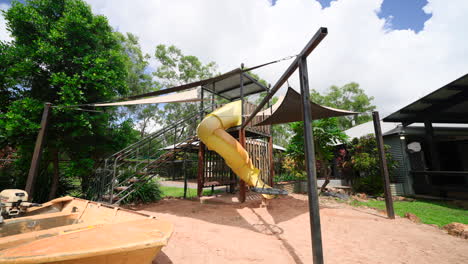 Luxury-Playground-With-Sunshade-Covering-Slide-into-Sand-Play-Pit-With-Boat-in-Backyard-of-Elegant-Tropical-Home-On-Large-Rural-Grounds