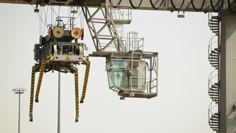 Container-crane-cabin-at-a-commercial-dock-during-daylight,-clear-sky