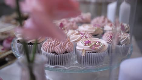 tasty-cupcakes-wtih-delicious-icing-on-table,-shallow-depth-of-field-dolly,-cinematic-shot