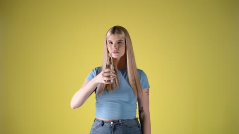 Attractive-happy-woman-gives-a-toast-to-the-camera-with-transparent-water-bottle