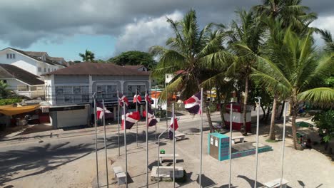 Aerial-Revealing-of-Las-Terrenas-Seaside-Town-with-Dominican-Republic-Flags