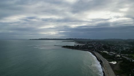 Aerial-drone-shot-of-quaint-coastal-town-under-dramatic-cloudy-skies-during-dusk