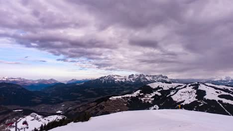 Snowy-rocky-peaks-and-flowing-cloudscape,-time-lapse-view
