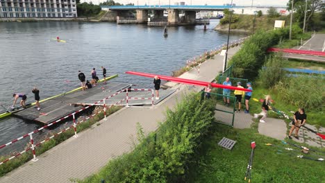 Recreational-team-carrying-a-rowing-boat-to-navigate-the-city's-river