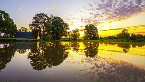 Colorful-sunrise-and-sky-moving-reflected-in-lake