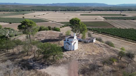 Luftaufnahme-Der-Architektonischen-Eleganz-Der-Ermita-Del-Poblado-De-San-Julián,-Einem-Zeitlosen-Symbol-Spiritueller-Hingabe-In-Marmolejo,-Umrahmt-Von-Der-Malerischen-Kulisse-Landwirtschaftlicher-Felder