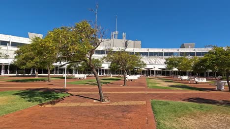 Moviéndose-A-Través-De-Terrenos-Ajardinados-Del-Edificio-De-La-Universidad-En-Un-Día-Claro-Y-Soleado